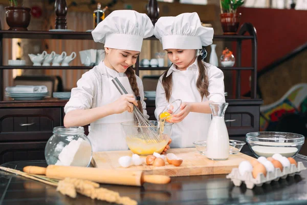 Chicas divertidas niños están preparando la masa en la cocina. — Foto de Stock