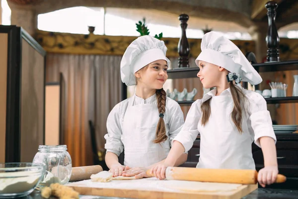 Chicas divertidas niños están preparando la masa en la cocina. — Foto de Stock