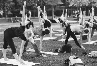 Bir grup genç gün batımında Park'ta yoga yapıyor.