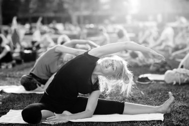 Bir grup genç gün batımında Park'ta yoga yapıyor.