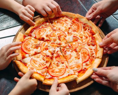 Ahşap masada Pizza dilimleri alarak eller, yakın görünüm.