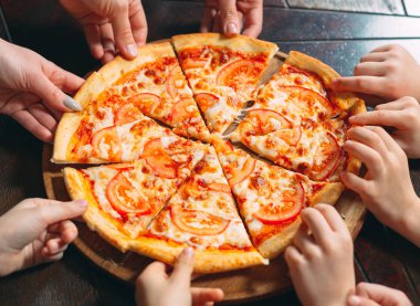 Ahşap masada Pizza dilimleri alarak eller, yakın görünüm.