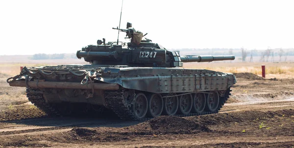 Бронированный танк едет по бездорожью. Танковые учения в деревне . — стоковое фото