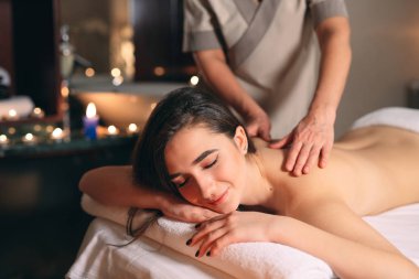 Spa, masaj. Genç siyah saçlı güzel kız masaj yapıyor..