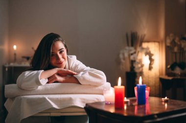 Spa, masaj. Genç, siyah saçlı güzel bir kız masaj bekliyor..