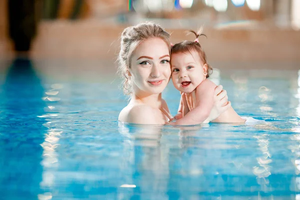 妈妈和宝宝在游泳池里游泳. — 图库照片