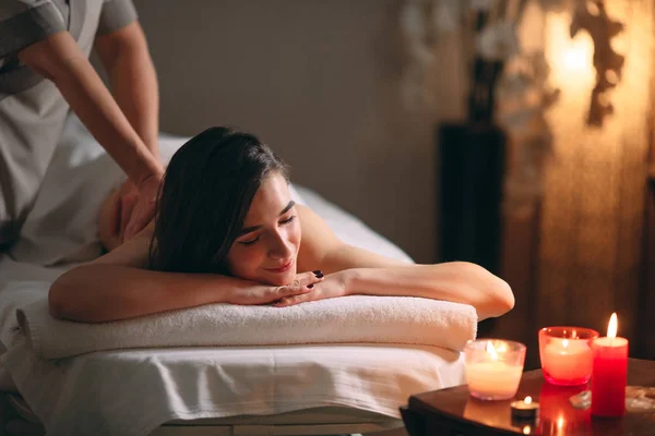 Spa, massage. Ung mörkhårig vacker flicka som gör massage. — Stockfoto