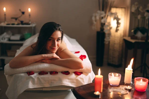 Spa, masaje. Una joven guapa morena está esperando un masaje. —  Fotos de Stock