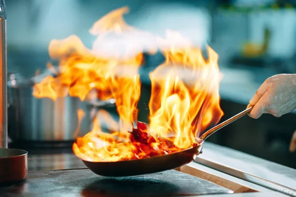 Cuisine moderne. Les cuisiniers préparent les repas sur la cuisinière dans la cuisine du restaurant ou de l'hôtel. Le feu dans la cuisine. — Photo