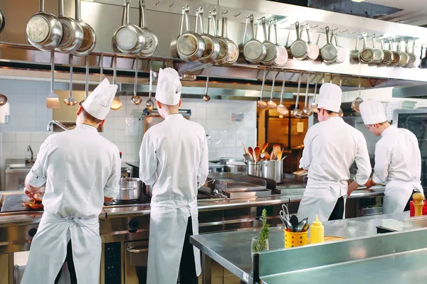 Cocina moderna. Los cocineros preparan comidas en la estufa en la cocina del restaurante u hotel. El fuego en la cocina. — Foto de Stock