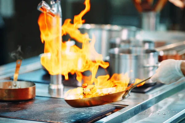 Chef cocinando verduras en sartén wok. Dof poco profundo. — Foto de Stock