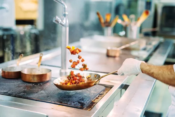 Chef cocinando verduras en sartén wok. Dof poco profundo. — Foto de Stock