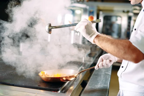 Chef cocinando verduras en sartén wok. Dof poco profundo. — Foto de Stock