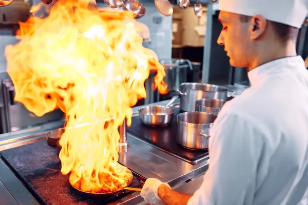 Современная кухня. Повара готовят блюда на плите на кухне ресторана или отеля. Пожар на кухне. — стоковое фото