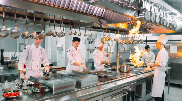 Modern mutfak. Aşçılar restoranın ya da otelin mutfağındaki ocakta yemek hazırlarlar. Mutfaktaki yangın.. — Stok fotoğraf