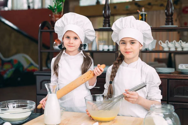 Chicas divertidas niños están preparando la masa en la cocina. — Foto de Stock