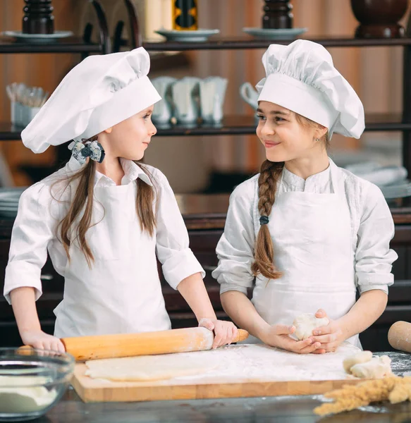 Chicas divertidas niños están preparando la masa en la cocina. — Foto de Stock