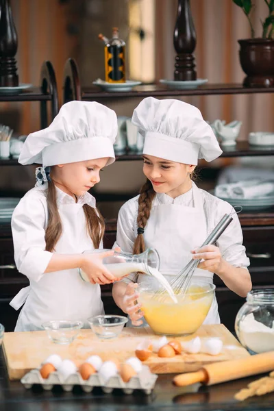 Chicas divertidas niños están preparando la masa en la cocina. — Foto de Stock