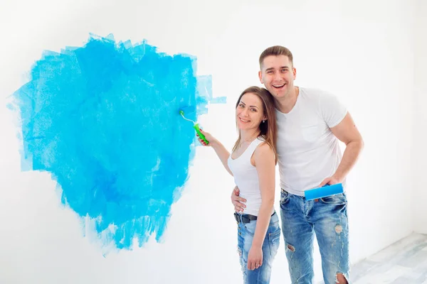 Happy couple painting walls in their new house ready for living together. — Stock Photo, Image