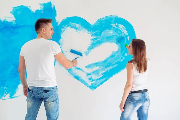 Happy couple painting walls in their new house ready for living together. — Stock Photo, Image