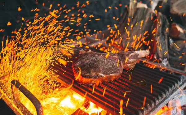 O bife de vaca é cozido em fogo. Costela de carne churrasco . — Fotografia de Stock