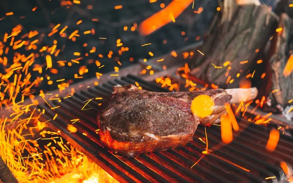 O bife de vaca é cozido em fogo. Costela de carne churrasco . — Fotografia de Stock