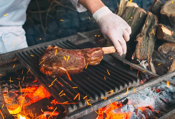 Chef cuisinier steak. Le cuisinier allume le feu. — Photo