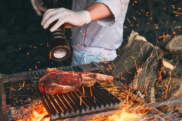 Chef Cooking steak. Cozinheiro vira a carne no fogo. — Fotografia de Stock