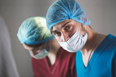 İşteki cerrahların portresi, üniforma içinde ameliyat, kameraya bakmak..