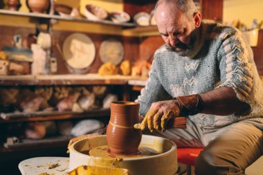 Çömlek atölyesi. Yaşlı bir adam kilden bir vazo yapar. Çamur modelliği