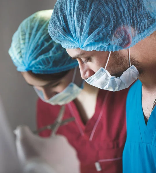 Gruppe von Chirurgen bei der Arbeit im Operationssaal. Reanimationsmediziner tragen Schutzmasken mit medizinischen Werkzeugen aus Stahl — Stockfoto