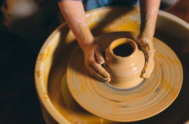 Çömlek atölyesi. Küçük bir kız kilden bir vazo yapar. Çamur modelliği