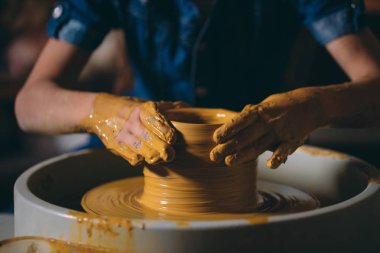 Çömlek atölyesi. Küçük bir kız kilden bir vazo yapar. Çamur modelliği
