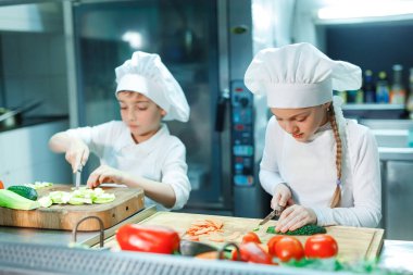 Şefler şapka çocuklar mutfakta sebze eziyet.