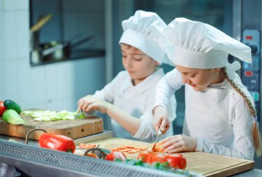 Şefler şapka çocuklar mutfakta sebze eziyet.