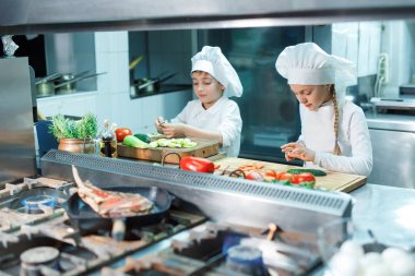 Şefler şapka çocuklar mutfakta sebze eziyet.