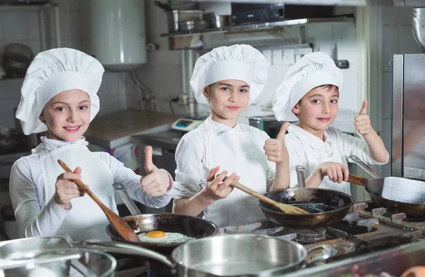 Los niños cocinan huevos en la cocina del restaurante. — Foto de Stock