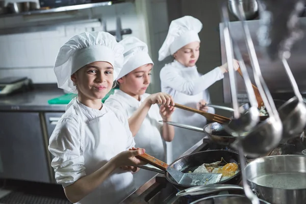 Los niños cocinan huevos en la cocina del restaurante. — Foto de Stock