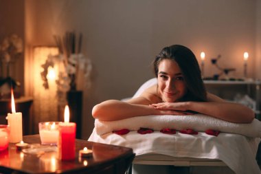 Spa, masaj. Genç, siyah saçlı güzel bir kız masaj bekliyor..