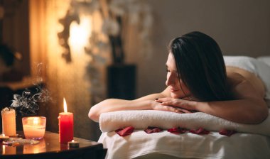 Spa, masaj. Genç, siyah saçlı güzel bir kız masaj bekliyor..