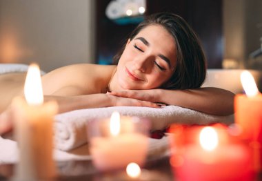 Spa, masaj. Genç, siyah saçlı güzel bir kız masaj bekliyor..