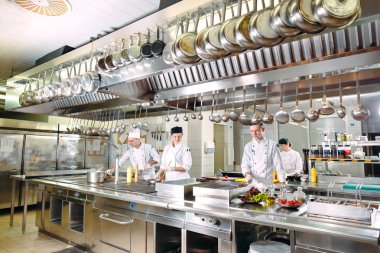 Modern mutfak. Aşçılar restoranın ya da otelin mutfağındaki ocakta yemek hazırlarlar. Mutfaktaki yangın..