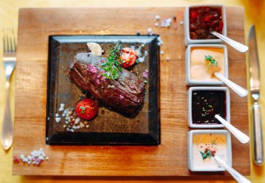 Restoran yemeği. Taze sebzeli ızgara domuz eti. Bitki ve baharatlı madalyonlar..