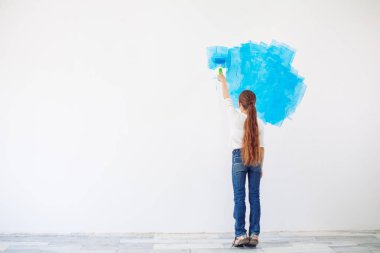 Apartmanda tamirat var. Mutlu çocuk duvarı mavi boyayla boyuyor.,