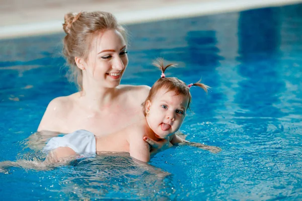 妈妈和宝宝在游泳池里游泳. — 图库照片