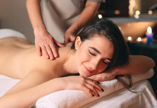 Spa, massage. Jeune fille brune belle faisant un massage. — Photo