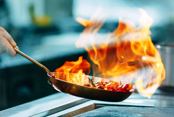 Сучасна кухня. Кухарі готують їжу на плиті на кухні ресторану або готелю. Вогонь на кухні . — стокове фото