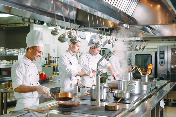 Cocina moderna. Los cocineros preparan comidas en la estufa en la cocina del restaurante u hotel. El fuego en la cocina. — Foto de Stock