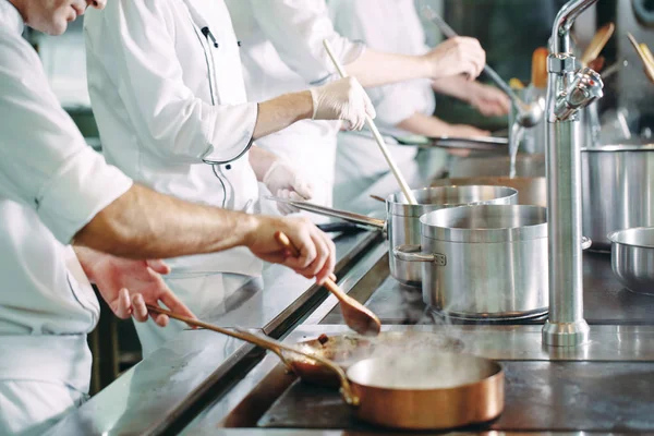 Chef cocinando verduras en sartén wok. Dof poco profundo. — Foto de Stock