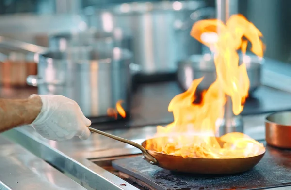 Chef cocinando verduras en sartén wok. Dof poco profundo. — Foto de Stock